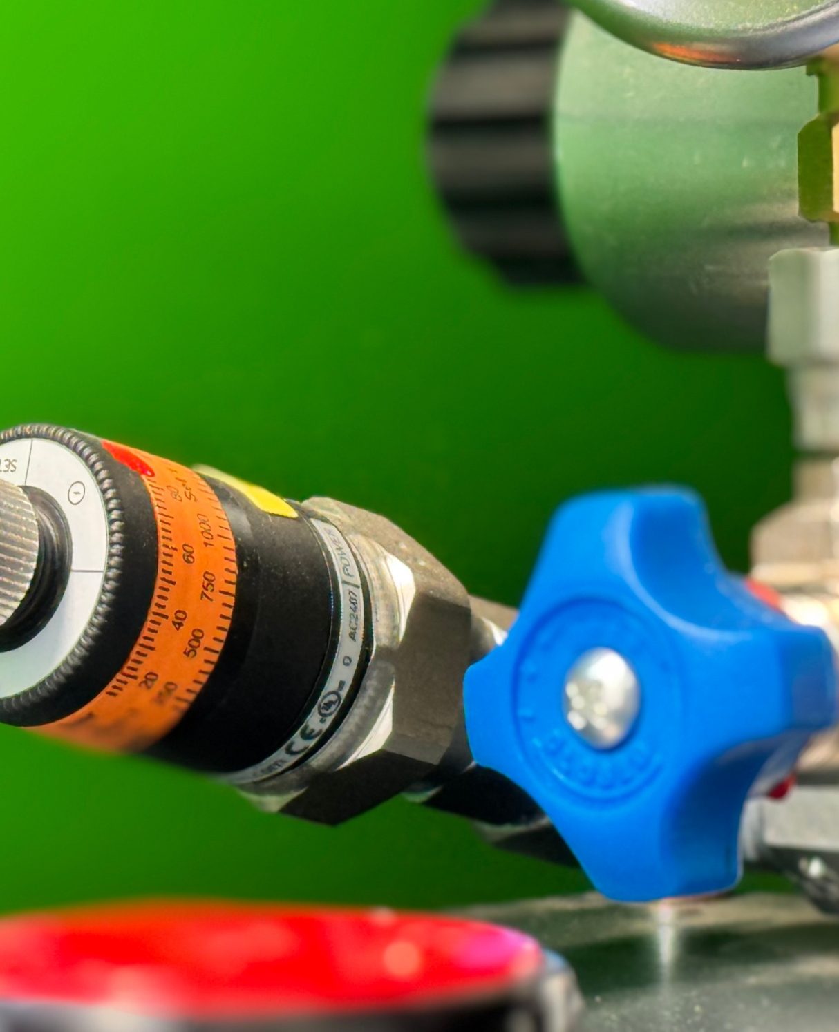 Maschine mit Motor, Manometer und Schläuchen in einem grünen Maschinengestell.